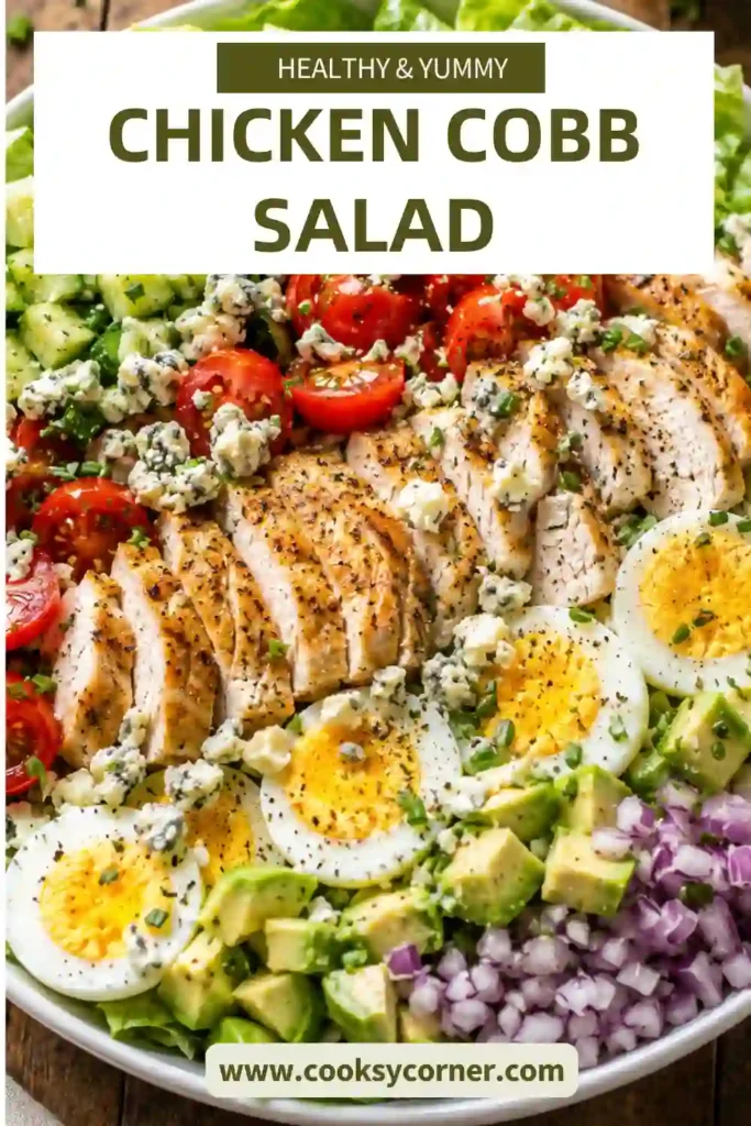 A colorful Chicken Cobb Salad with grilled chicken, avocado, hard-boiled eggs, tomatoes, cucumber, red onion, blue cheese, and homemade ranch dressing served in a large bowl.