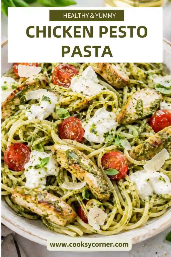 Close-up of Chicken Pesto Pasta coated in homemade basil pesto with chicken breast, tomatoes, mozzarella, and Parmesan cheese. Fresh basil leaves garnish the pasta.