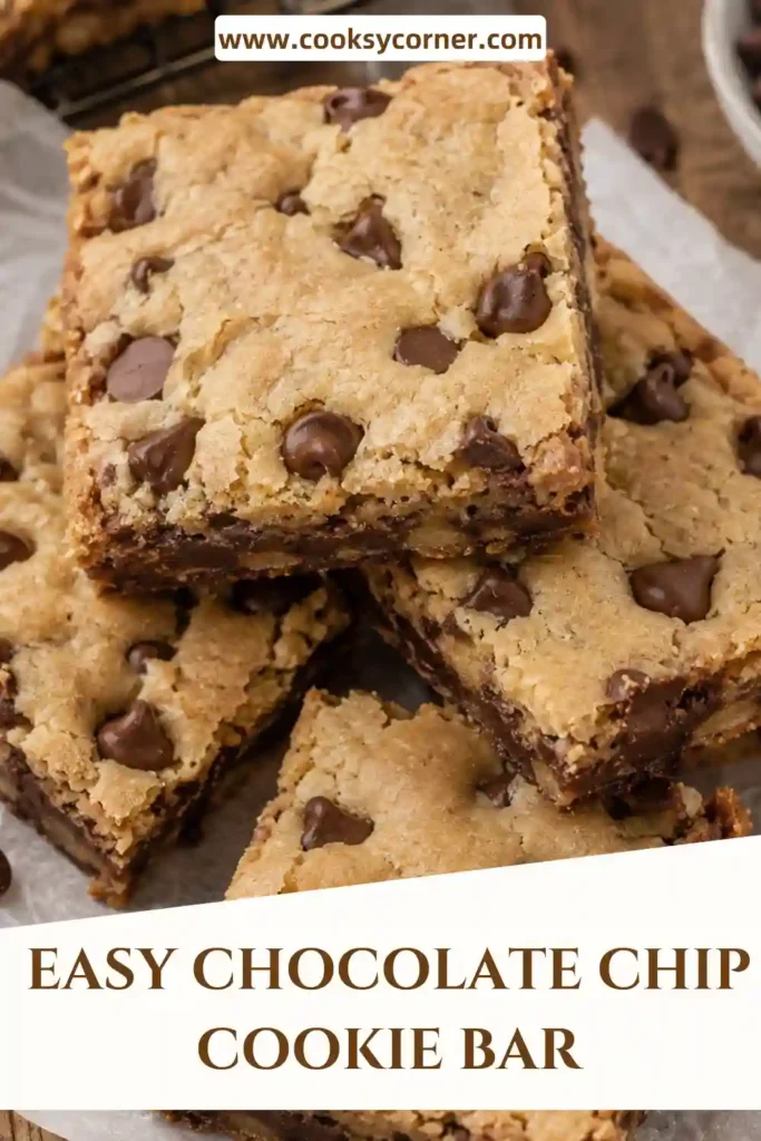 Chocolate Chip Cookie Bars sliced into squares and served on a baking rack with extra chocolate chips scattered nearby.