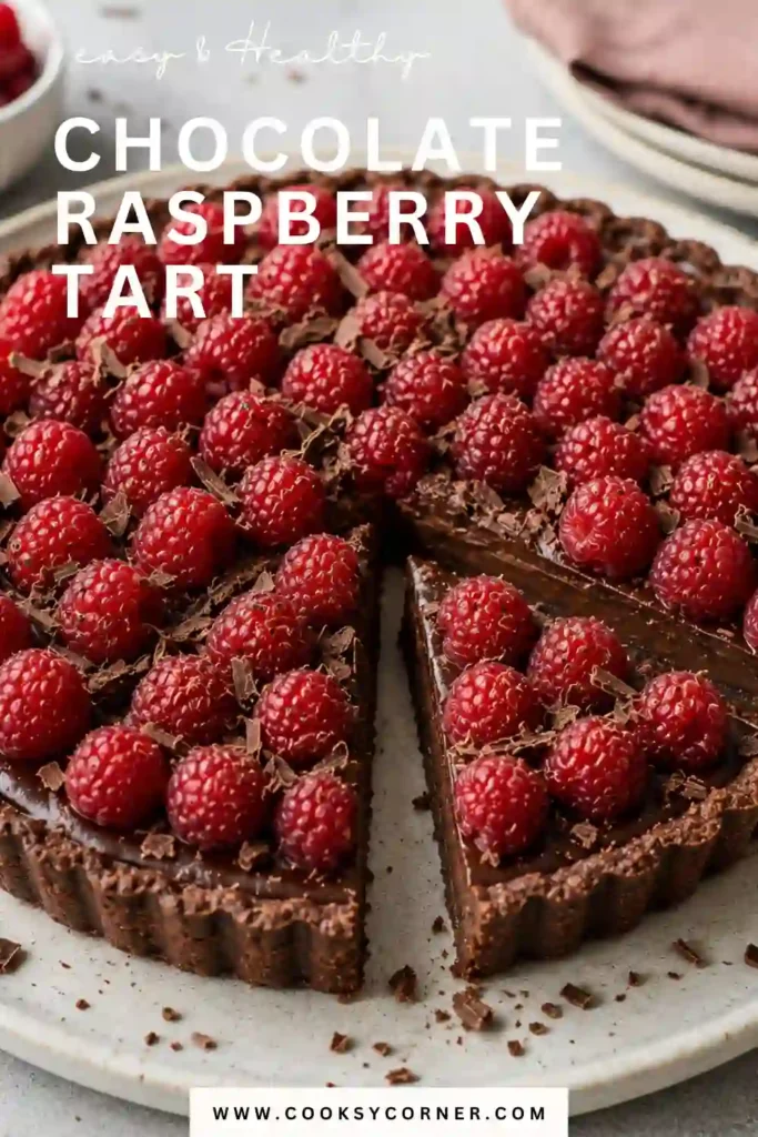 A sliced raspberry chocolate tart with rich bittersweet chocolate ganache, an Oreo cookie crust, and fresh raspberries. The creamy filling contrasts with the crisp crust and juicy berries.