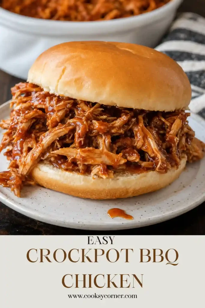 Crockpot BBQ Chicken served on a soft bun as a pulled BBQ chicken sandwich. The shredded chicken is coated with a rich, smoky barbecue sauce.