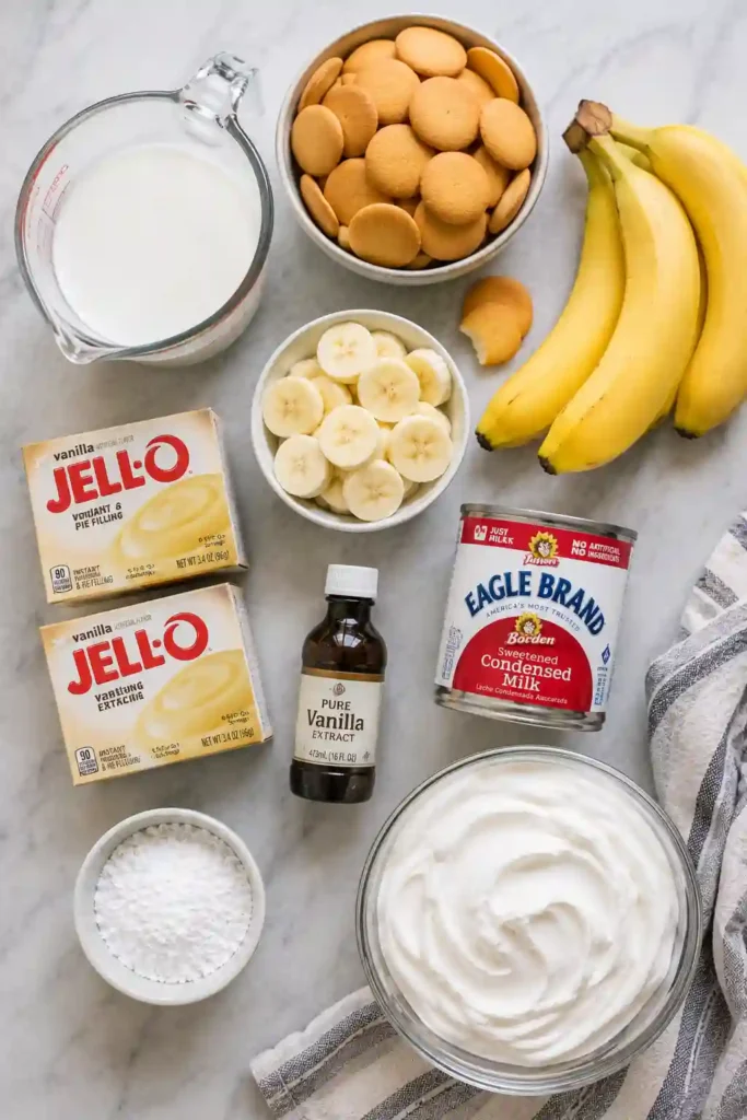 No-bake Easy Banana Pudding served in a trifle bowl with whipped cream, fresh bananas, and crunchy vanilla wafer cookies.