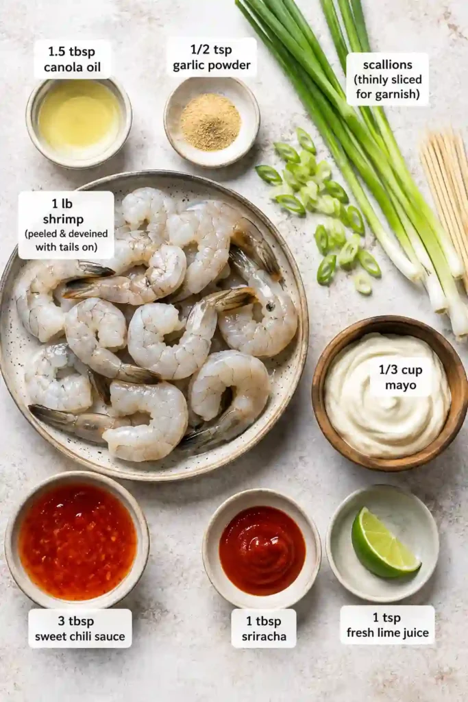 Easy grilled shrimp recipe featuring tender shrimp skewers with smoky grill marks and creamy spicy bang bang sauce. The finished shrimp are garnished with thinly sliced green scallions.