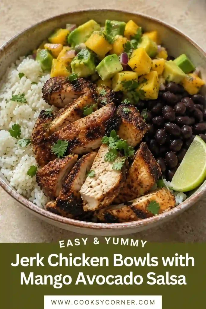 Caribbean-inspired jerk chicken rice bowl filled with golden spiced chicken thighs, coconut rice, black beans, diced mango, avocado, red onion, and cilantro.