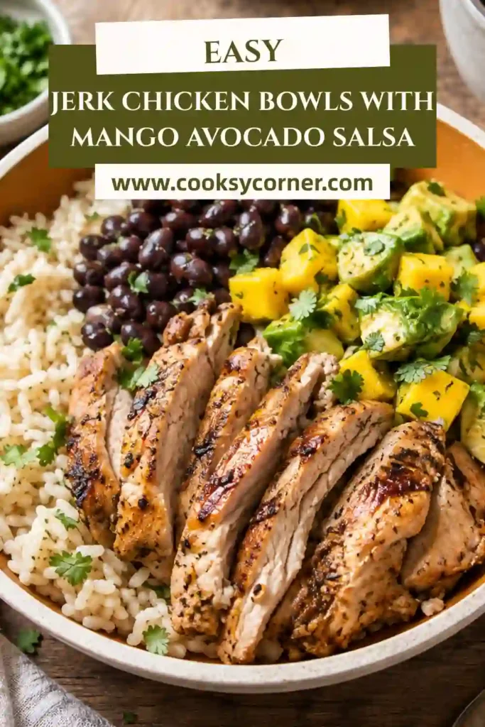 A colorful bowl filled with jerk chicken, coconut lime rice, black beans, and fresh mango avocado salsa garnished with cilantro and lime wedges.