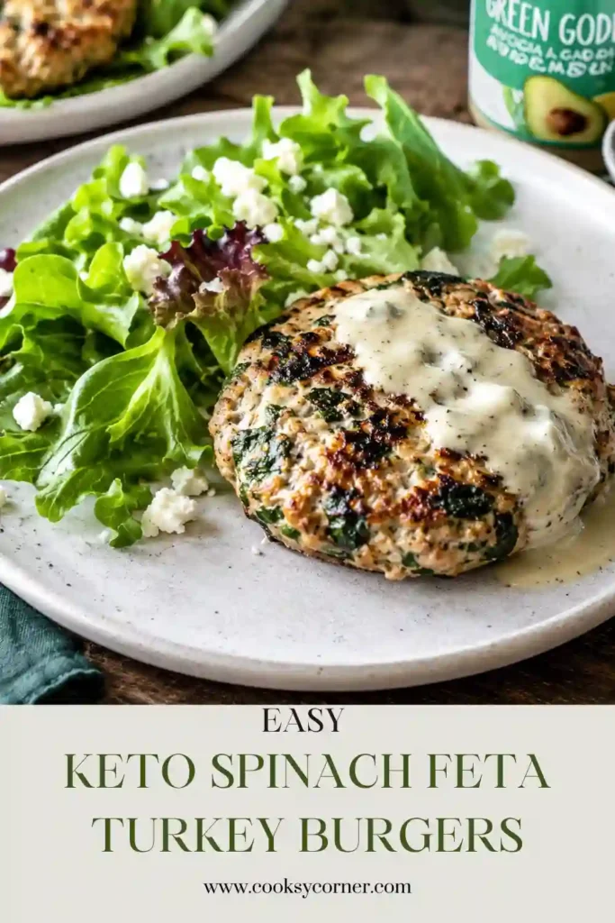 Keto Spinach Feta Turkey Burgers with golden-brown patties filled with fresh spinach, crumbled feta, parsley, and dill. The burgers are served over crisp mixed salad greens.