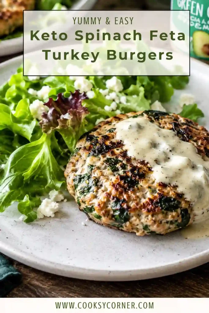 Spinach feta turkey burgers served bunless over fresh green salad with creamy dressing. Pieces of feta and spinach are visible throughout the juicy turkey patties.