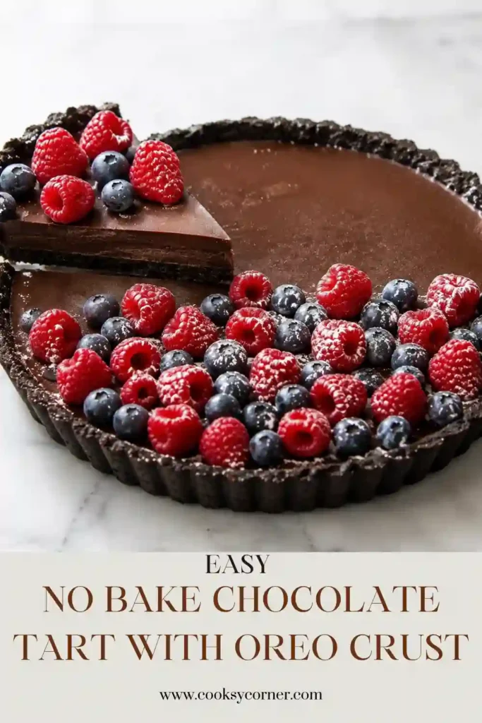 Oreo chocolate tart filled with smooth semi-sweet chocolate ganache and topped with fresh mixed berries. The chilled no-bake dessert has a rich dark crust and glossy chocolate center.