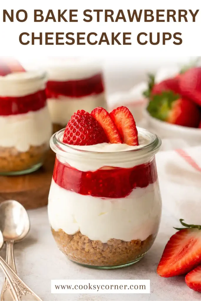 Close-up of No-Bake Strawberry Cheesecake Cups topped with sliced strawberries and dark chocolate. The creamy cheesecake layers are visible through the glass.