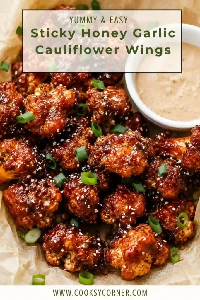 Honey garlic cauliflower bites served hot with a glossy homemade glaze and creamy spicy ranch on the side. The breaded cauliflower is crisp and golden with sesame seeds scattered over the top.