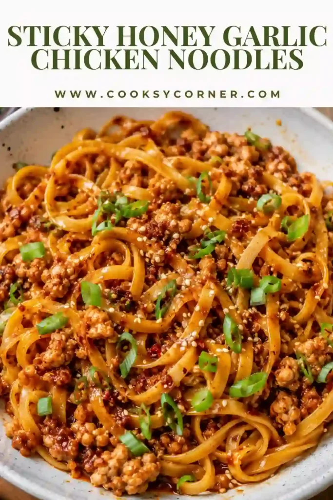 1. Sticky Honey Garlic Chicken Noodles tossed with golden ground chicken and crisp vegetables in a glossy honey garlic sauce. The finished noodles are topped with sliced scallions and toasted sesame seeds.