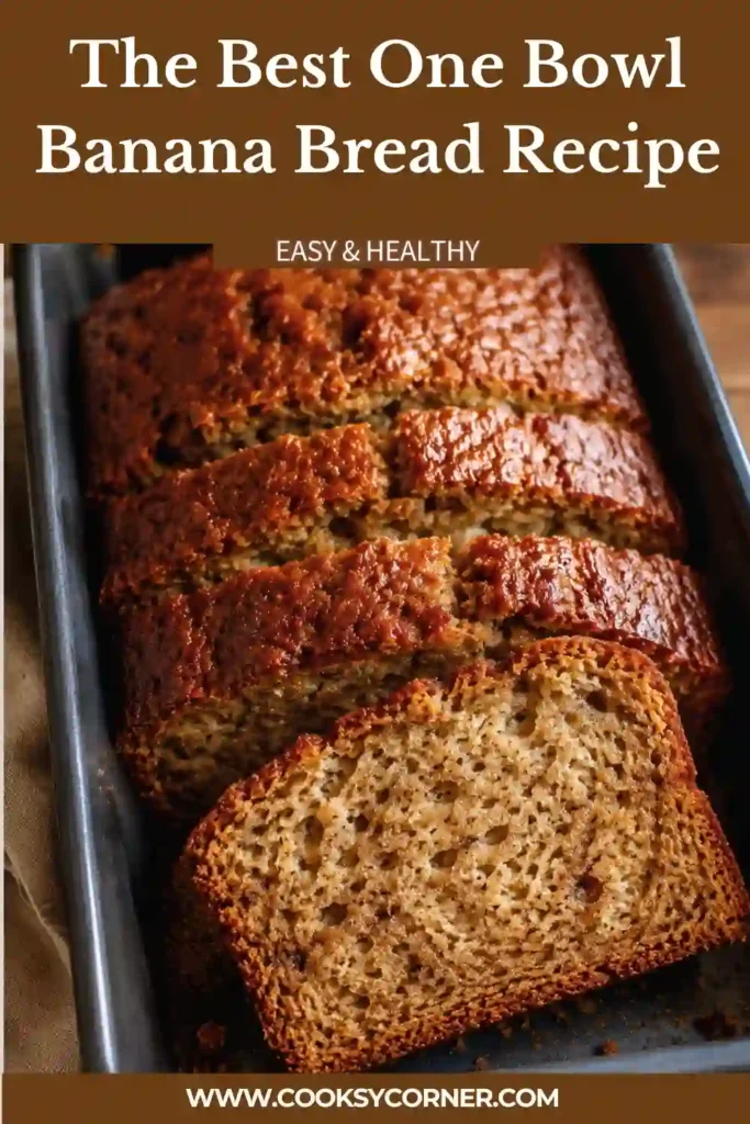 The Best One-Bowl Banana Bread Recipe baked into a golden loaf with a soft, moist banana center. Sliced ripe bananas and a lightly browned crust highlight the homemade quick bread.