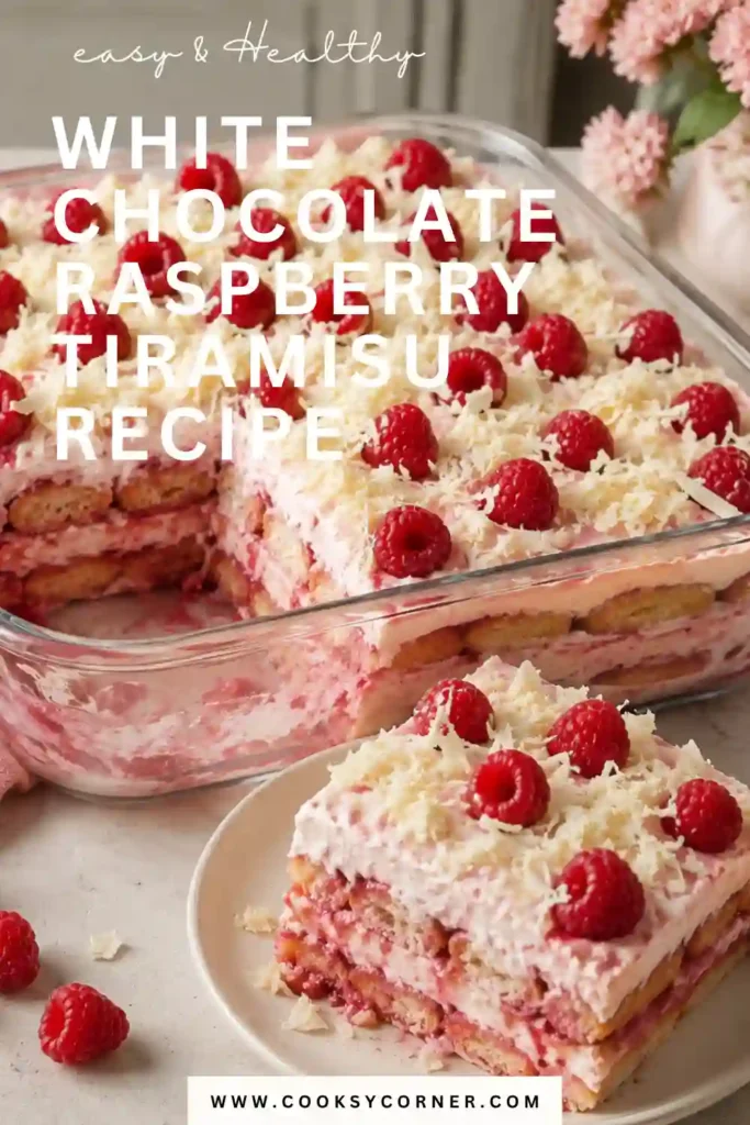 Slice of raspberry tiramisu showing pink berry-soaked ladyfingers and thick layers of creamy mascarpone filling. White chocolate shavings and fresh raspberries create an elegant finish.