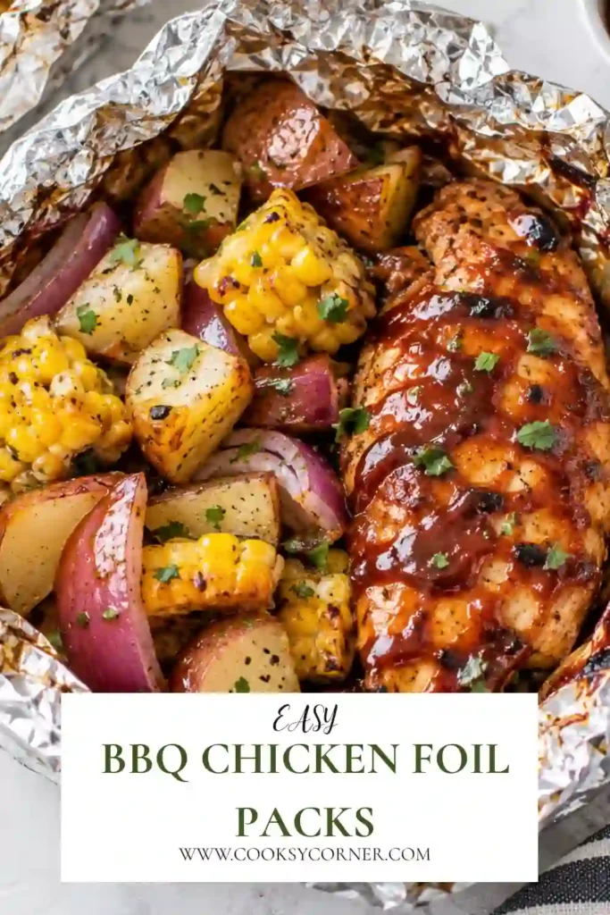 Freshly grilled BBQ chicken foil packets served open to reveal tender chicken, potatoes, peppers, and onion. Smoky barbecue sauce gives the chicken and vegetables a rich glazed finish.