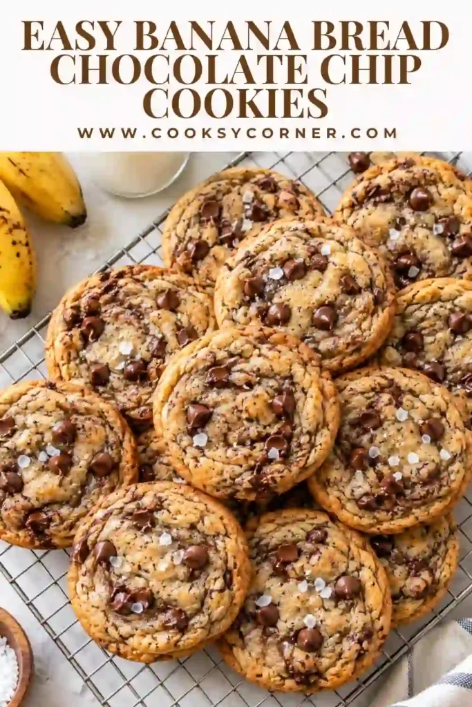 Brown butter banana cookies with chocolate chips and flaky sea salt arranged on a baking tray. The cookies have soft centers, lightly crisp edges, and visible pieces of melted chocolate.