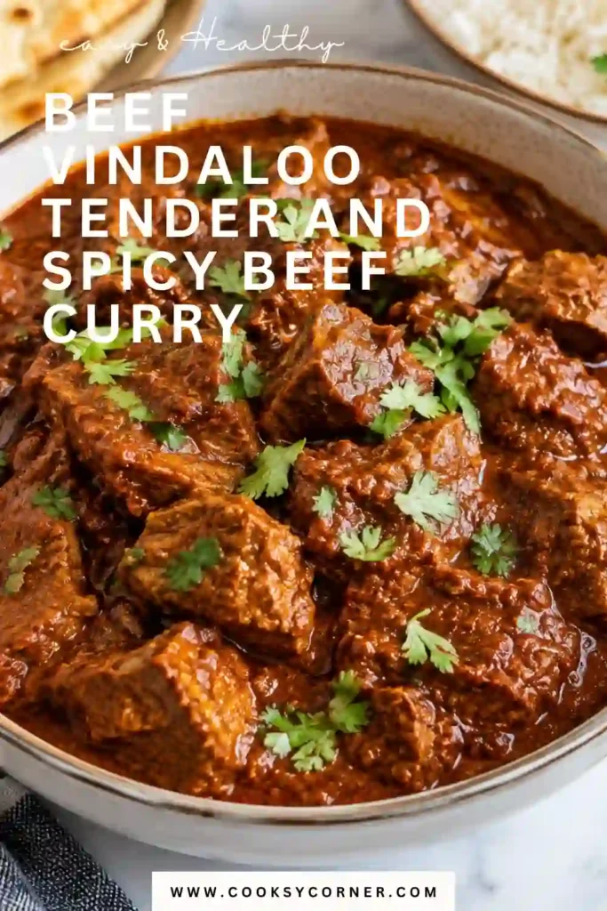 Beef Vindaloo served with fluffy basmati rice and warm naan. Tender beef chunks are coated in a thick, spicy curry sauce made with caramelized onion, garlic, tomato, vinegar, and aromatic spices.