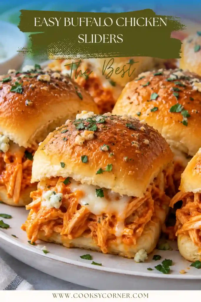 Baked Buffalo Chicken Sliders arranged in a casserole dish with melted cheese and saucy shredded chicken. The golden dinner rolls are brushed with seasoned butter for extra savory flavor.