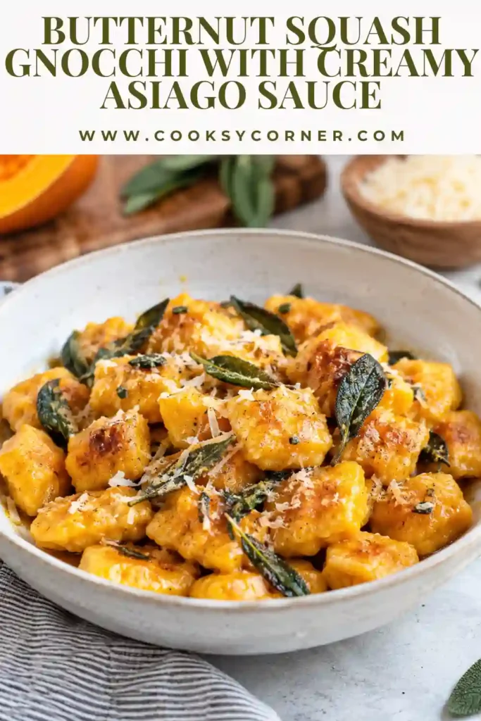 Creamy butternut squash gnocchi coated in a rich Asiago cream sauce with black pepper and nutmeg. The sauce clings to the small golden dumplings in a skillet.