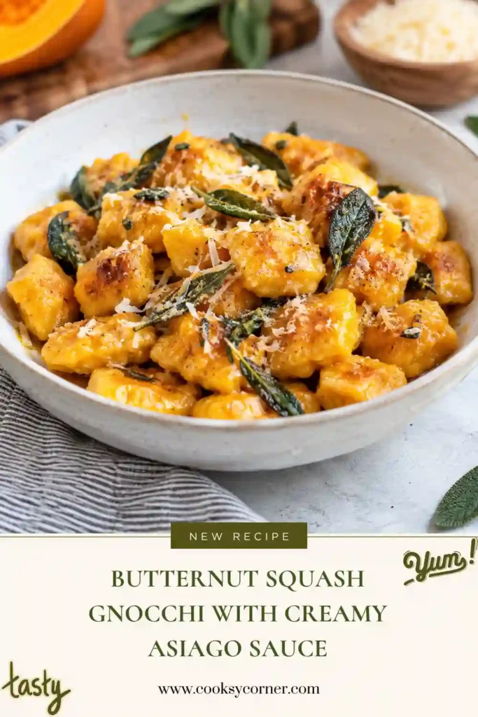 Butternut squash gnocchi served in a shallow bowl with a creamy Asiago-style cheese sauce. The tender golden dumplings are coated in a velvety sauce flecked with black pepper.