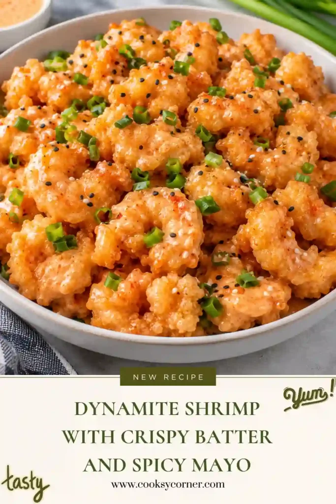 Dynamite shrimp piled in a bowl and coated with creamy orange sriracha mayo. The golden fried shrimp have a crisp coating beneath the sauce.
