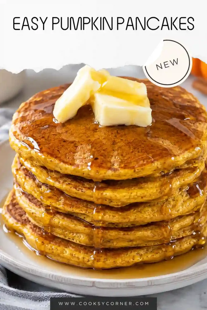 Fluffy Pumpkin Pancakes stacked on a breakfast plate and served warm with butter and maple syrup. The golden pancakes are made with pumpkin puree and warming fall spices.