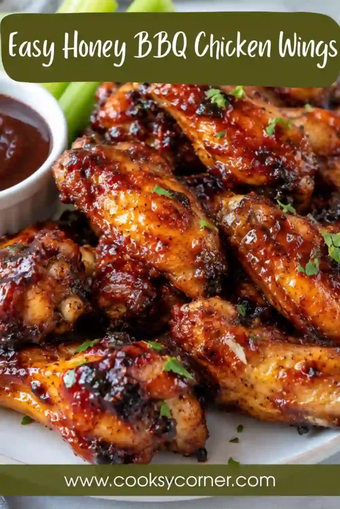 Honey BBQ Chicken Wings coated in a glossy, caramelized barbecue glaze and arranged on a serving platter. The golden oven-baked chicken wings have a rich, sticky sauce with sweet and smoky flavors.