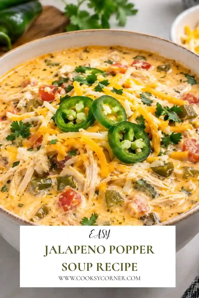 Jalapeno Popper Soup served in a bowl with creamy broth, shredded chicken, jalapenos, cheddar cheese, and crispy turkey bacon. This hearty soup has a rich, cheesy texture and colorful toppings.