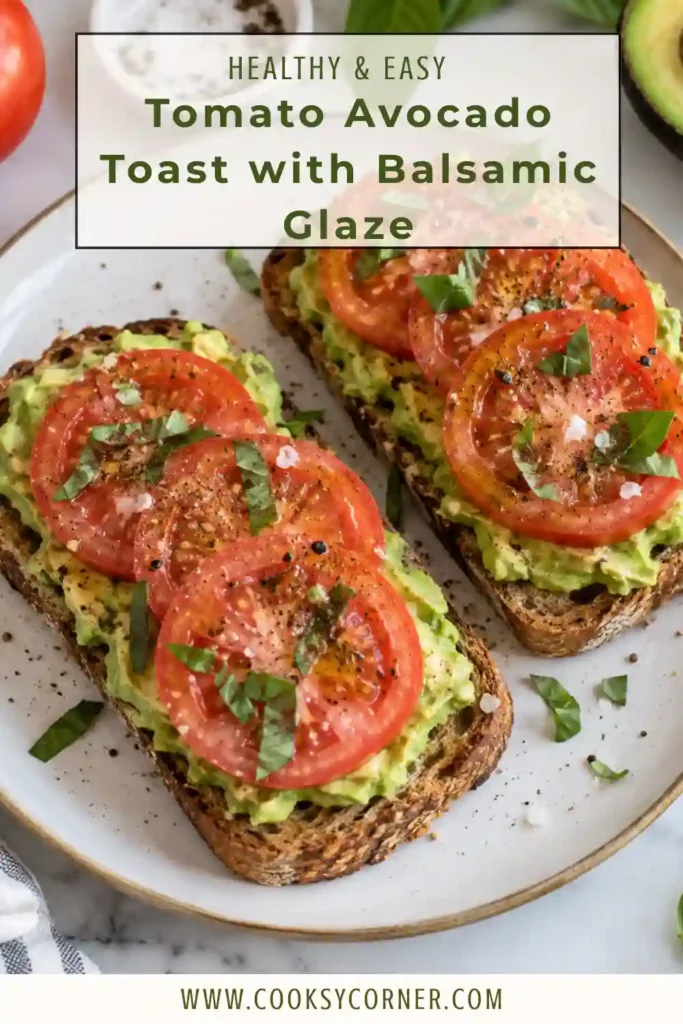 Tomato avocado toast on a plate with creamy mashed avocado, thick tomato slices, and a drizzle of balsamic glaze. The toppings rest on a golden slice of toasted artisan bread.