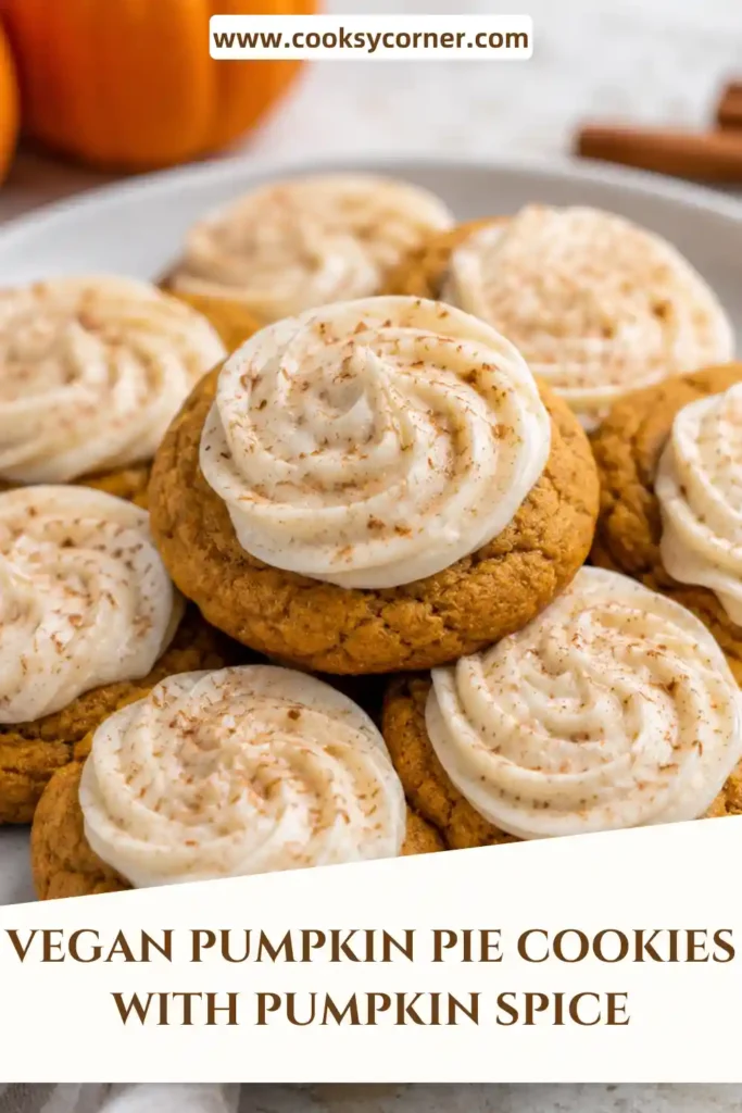 Pumpkin thumbprint cookies arranged on a serving plate with smooth pumpkin filling in the center. These vegan fall cookies are topped with whipped cream and warm pumpkin pie spice.