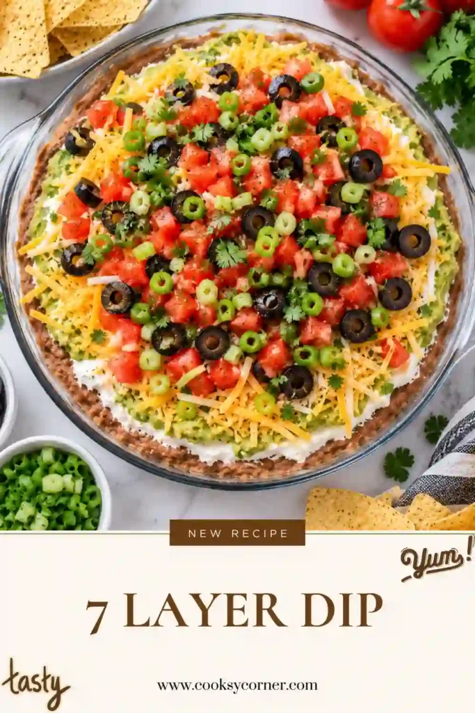 7 Layer Dip with refried beans, guacamole, sour cream, cheddar cheese, tomatoes, black olives, and green onions. The colorful layered party dip is served chilled with tortilla chips.