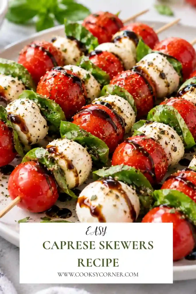Fresh tomato mozzarella skewers layered with basil and arranged on a serving platter. Balsamic glaze and olive oil add a glossy finish to this easy Italian-inspired appetizer.